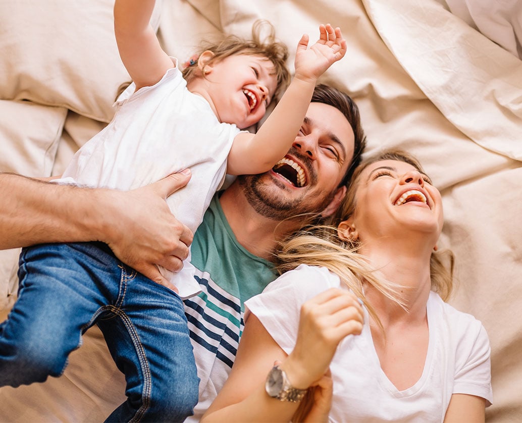 familia-deitada-na-cama-a-rir